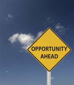 A stock photo featuring a road sign that says "OPPORTUNITY AHEAD" in front of a blue sky.