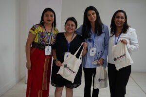 Four women smile into the camera, holding bags that say Filantropis.